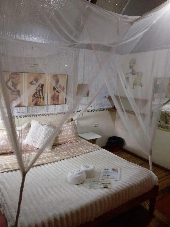 Canopy bed with patterned cushions — Family Room with Garden View