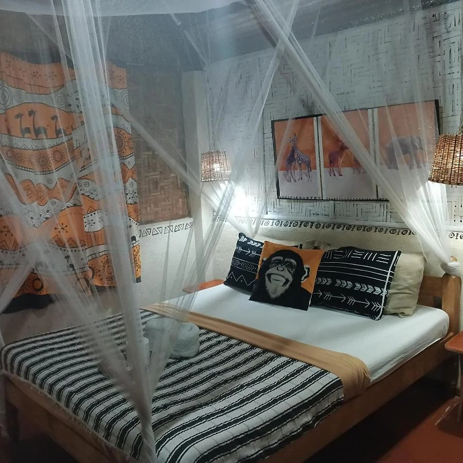 Guestroom with canopy bed, seating and eclectic textiles